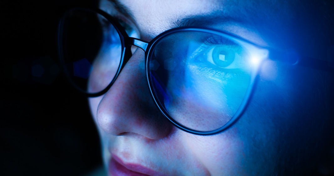 Girl works on internet. Reflection at the glasses from laptop. Close up of woman's eyes with black female glasses for working at a computer. Eye protection from blue light and rays.