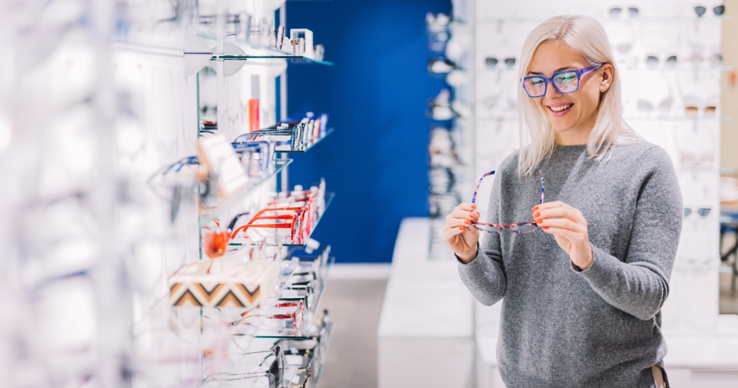 Woman looking at glasses at optic store.